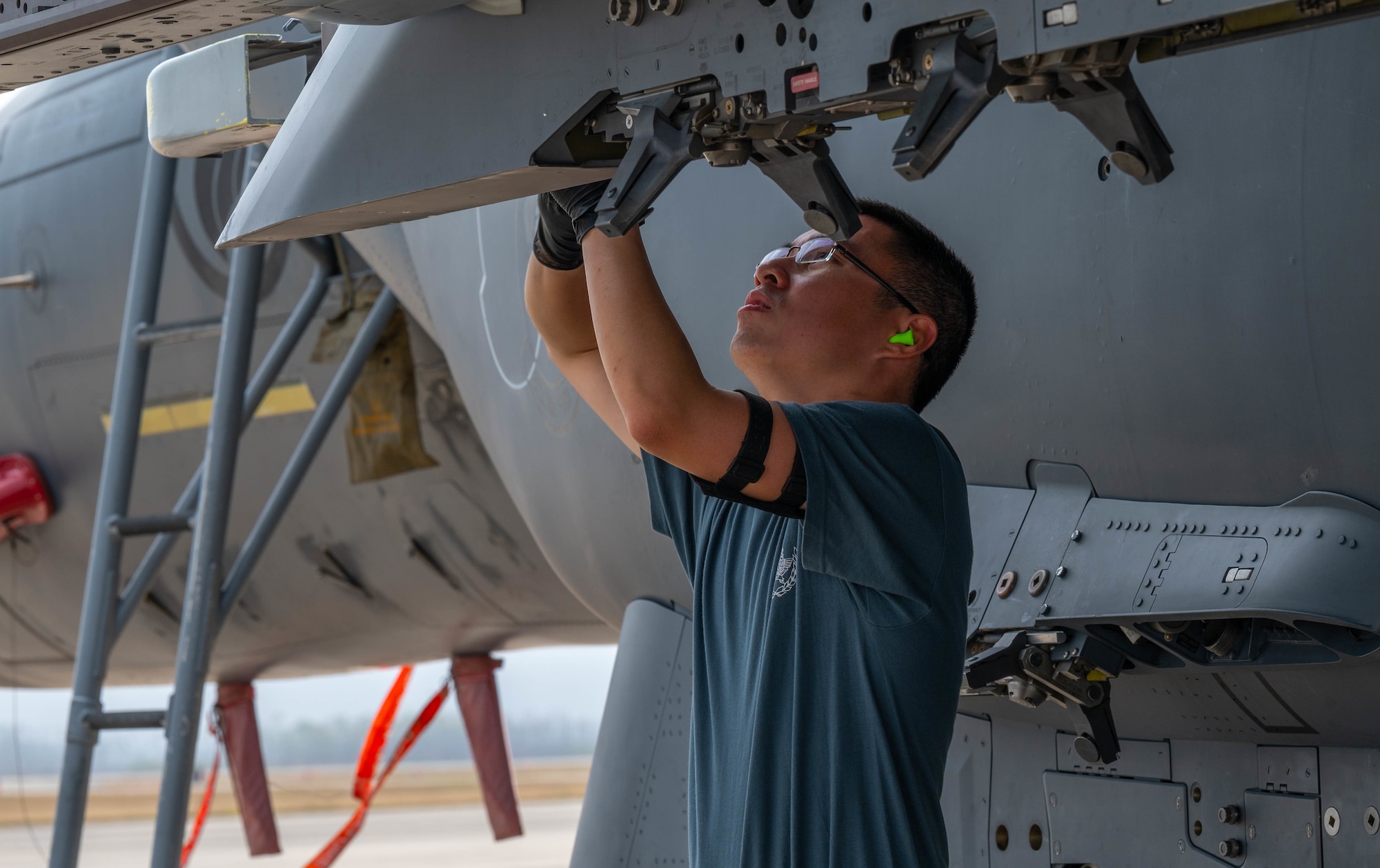 An airman loads a missile on an aircraft