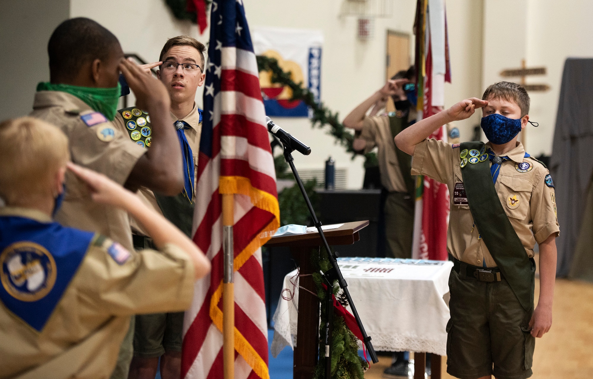Boy Scout Troop 162 members salute the flag during the opening ceremony of a monthly court of honor Dec. 13, 2021, in Fairborn, Ohio. In addition to the usual awarding of merit badges and advancement in scout ranks, the gathering marked the 75th anniversary of the troop, which began as the Wright-Patterson Air Force Base troop. (U.S. Air Force photo by R.J. Oriez)