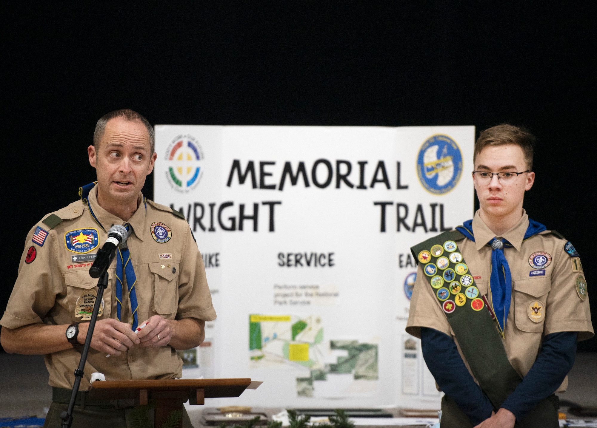 Boy Scout Troop 162 Scoutmaster Erik Oberg (left) talks to his scouts, their parents and friends about the troop’s history during its 75th anniversary celebration Dec. 13, 2021 at Abiding Christ Lutheran Church in Fairborn, Ohio. At right is Matthew Greiner, 13, the troop’s senior patrol leader and son of an active duty member of the Air Force. (U.S. Air Force photo by R.J. Oriez)