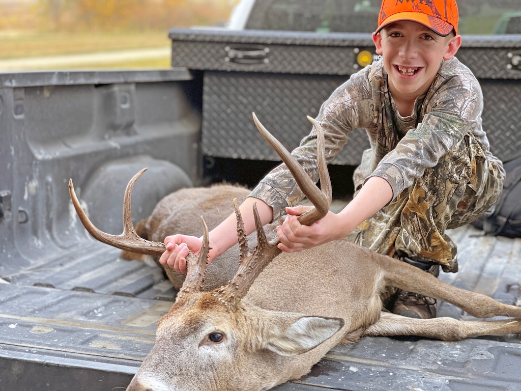 Young boy poses with deer
