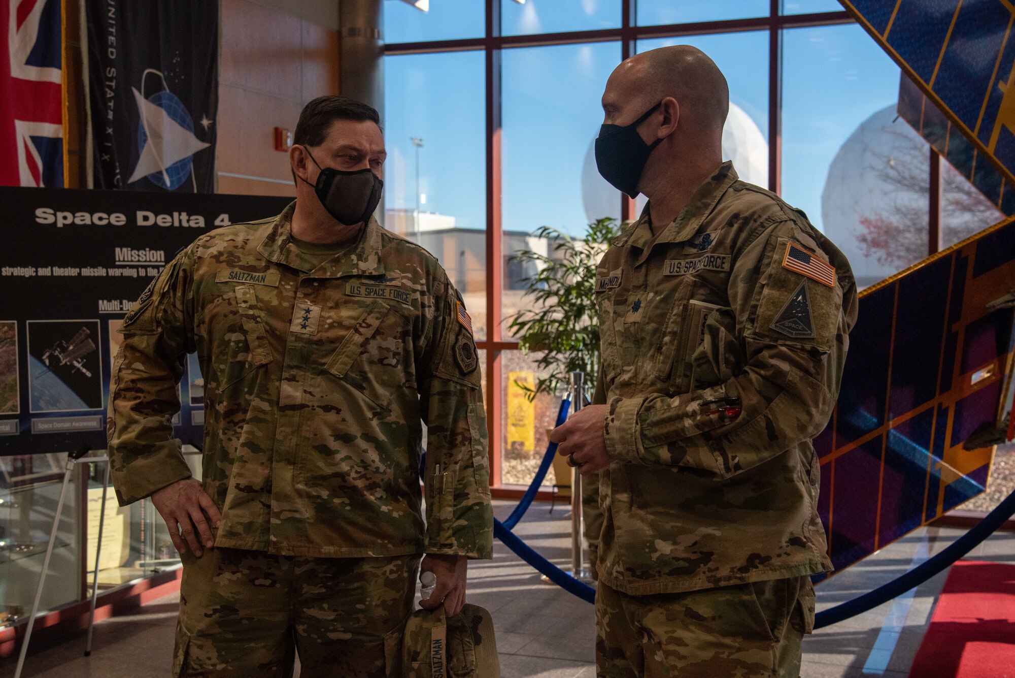 Lt. Gen. B. Chance Saltzman, Deputy Chief of Space Operations for Operations, Cyber and Nuclear, speaks with Lt. Col. Jason McCandless, Space Delta 4 deputy commander, in the Mission Control Station lobby at Buckley Space Force Base, Colo., Dec. 16, 2021.