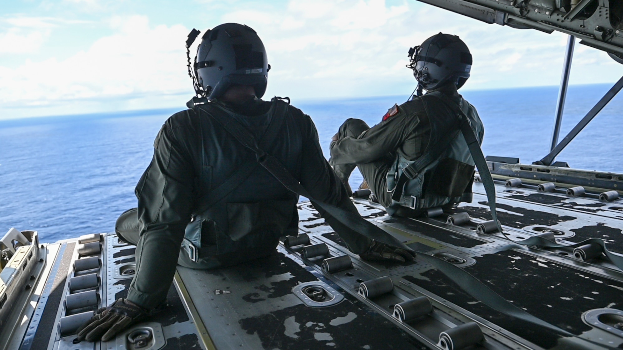 Two Airman sitting on the ramp of a C-130.