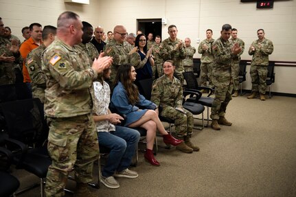 Oklahoma National Guard Master Sgt. Megan Mathews, battalion operations sergeant with the 1st Battalion, 160th Field Artillery Regiment, 45th Infantry Brigade Combat Team, holds her daughter's, Nora, hand as friends, family and fellow Guardsmen celebrate her during her promotion ceremony held at Joint Force Headquarters in Oklahoma City, Dec. 15, 2021.(Oklahoma National Guard Photo by Sgt. 1st Class Mireille Merilice-Roberts)