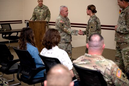 Oklahoma National Guard Master Sgt. Megan Mathews, operations sergeant for the 1st Battalion, 160th Field Artillery Regiment, 45th Infantry Brigade Combat Team, receives a coin during her promotion ceremony held at Joint Force Headquarters in Oklahoma City, Dec. 15, 2021. (Oklahoma National Guard photo by Sgt. 1st Class Mireille Merilice-Roberts)