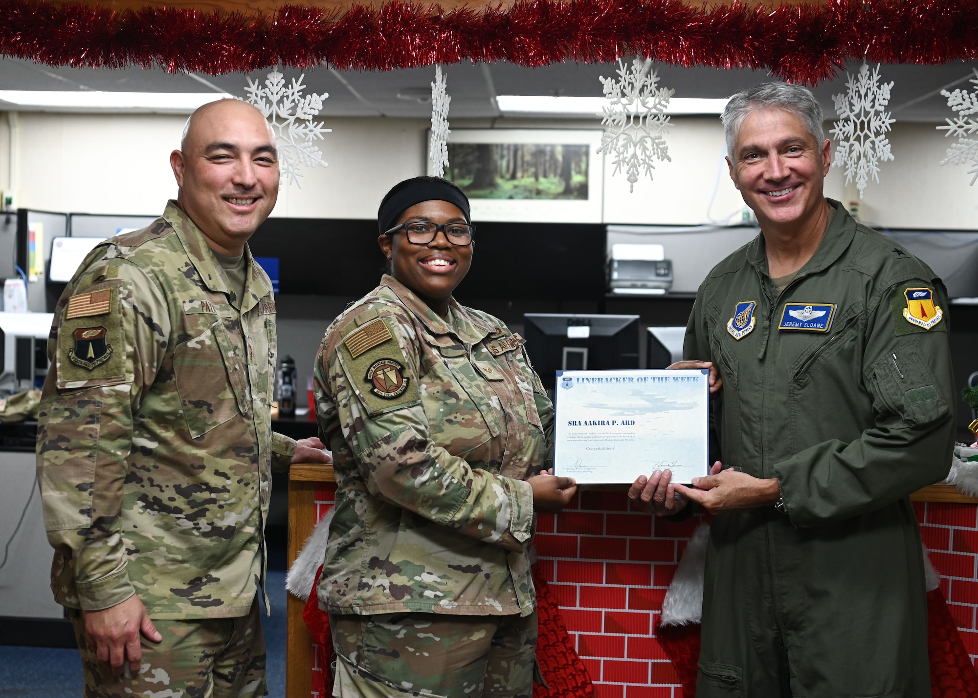 U.S. Air Force Senior Airman Aakira Ard, a customer service technician with the 36th Civil Engineer Squadron, receives the Linebacker of the Week award from Brig. Gen. Jeremy T. Sloane, commander of the 36th Wing, and Chief Master Sgt. John Payne, command chief for the 36th Wing, at Andersen Air Force Base, Guam, Dec. 15, 2021. The Team Andersen Linebacker of the Week recognizes outstanding enlisted, officer, civilian and total force personnel who have had an impact on achieving Team Andersen’s Mission, Vision and Priorities. (U.S. Air Force photo by Senior Airman Aubree Owens)