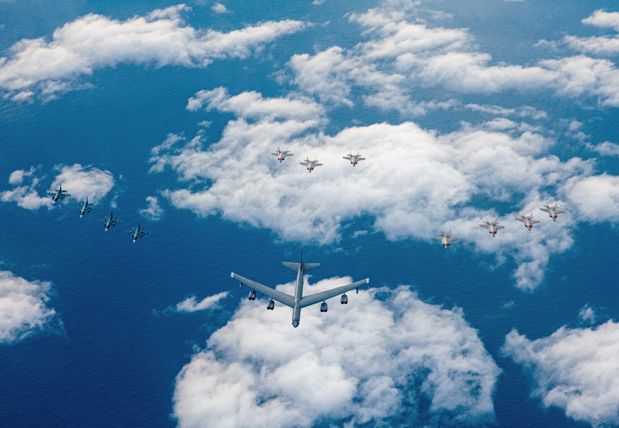Four Japanese Air Self Defense Force F-2s, one U.S. Air Force B-52H Stratofortress, and seven U.S. Air Force F-35A Lightning IIs fly in formation over the Pacific Ocean