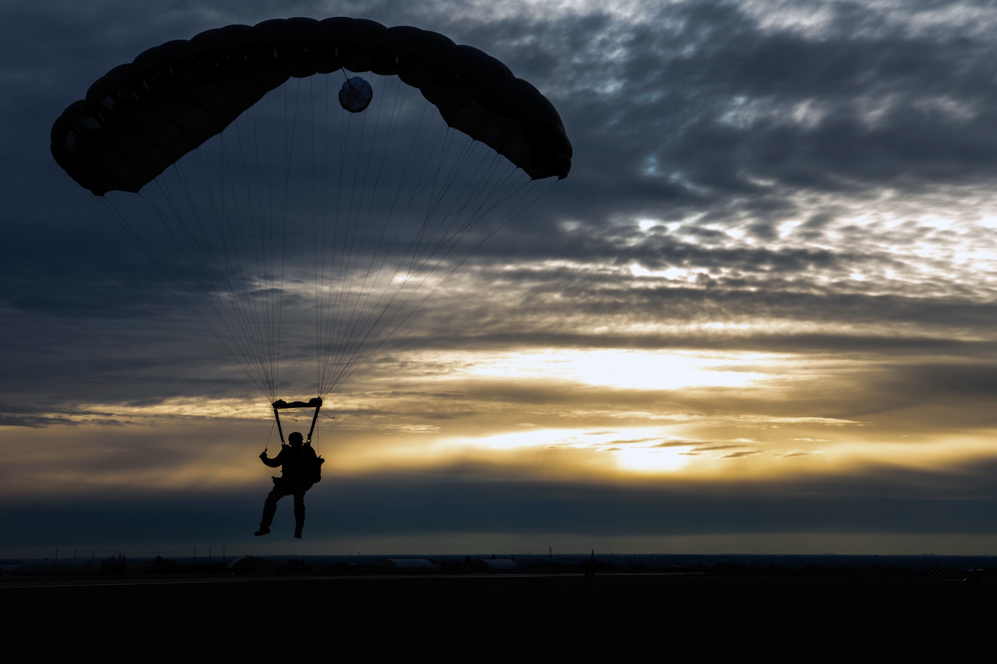 An Airman parachutes to the ground