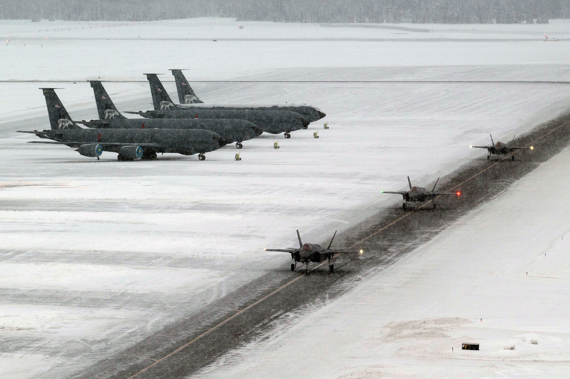 Three F-35A Lightning IIs taxi on the runway