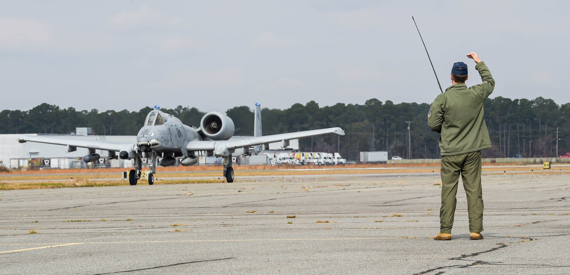 U.S. Air Force Maj. Will Piepenbring, 23rd Fighter Group assistant director of operations and A-10C Thunderbolt II pilot, marshals in an A-10C to be parked on the flight line during a WWII living history event at Douglas, Georgia, Dec. 4, 2021. Piepenbring spoke to attendees about his grandfather's service in WWII and the influence it had on him to go into aviation himself. (U.S. Air Force photo by Senior Airman Rebeckah Medeiros)
