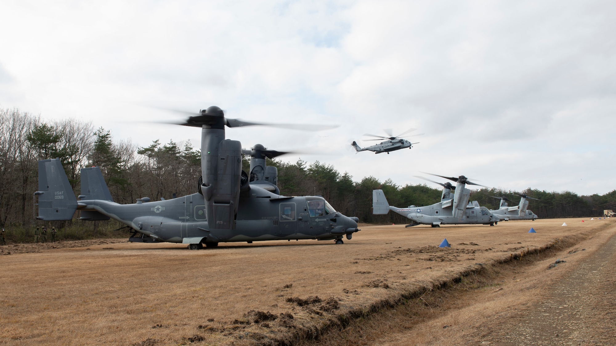 Four helicopters in a row taking off.