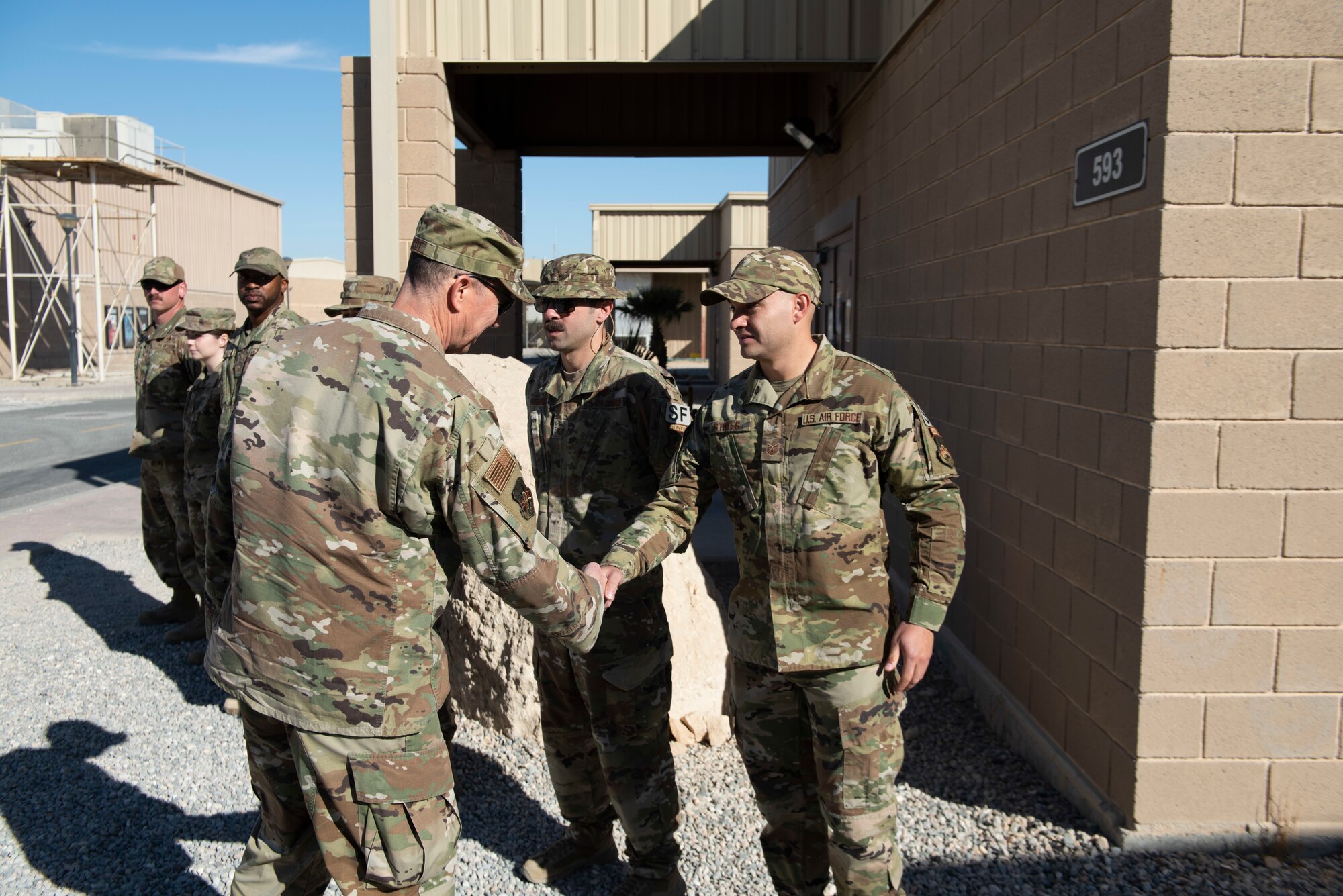 An Airman receives a coin from an Airman