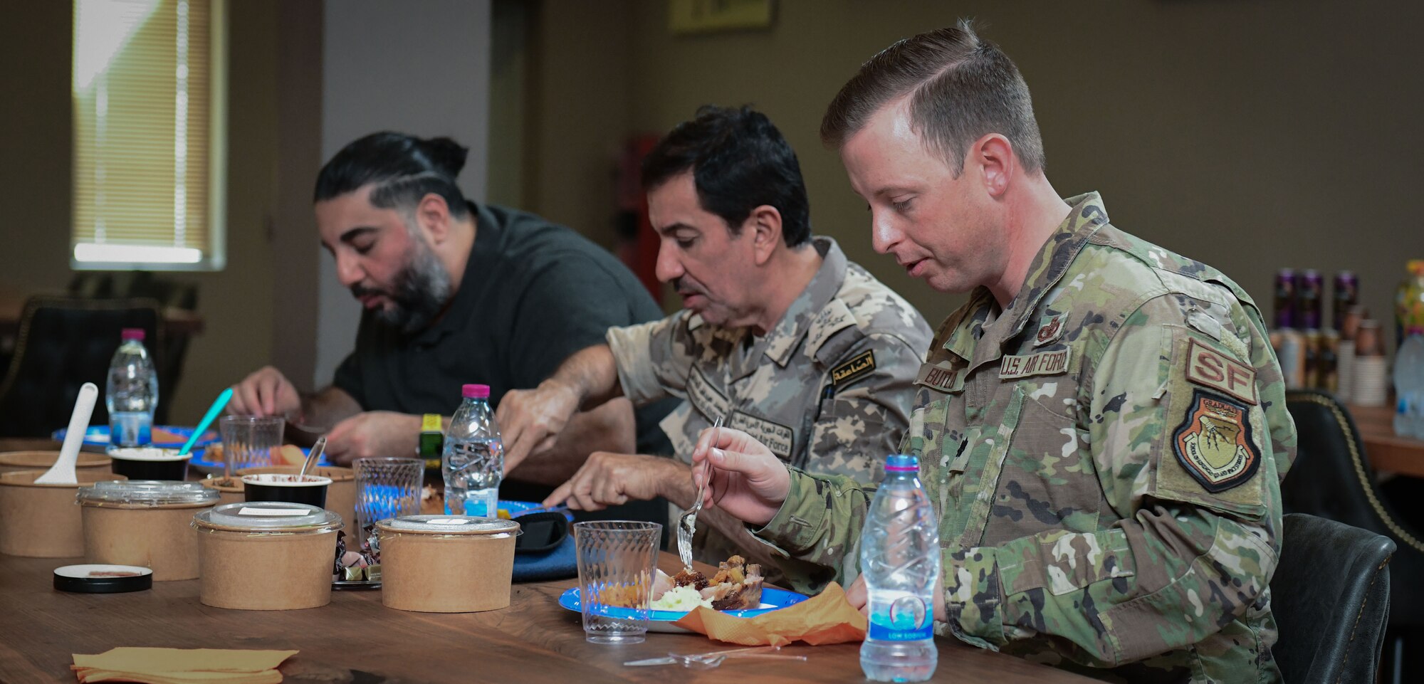 U.S. and Qatari service members sit down to share a meal.