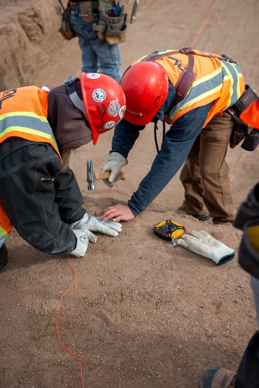 Construction workers affix a plum line while working on the new fitness center