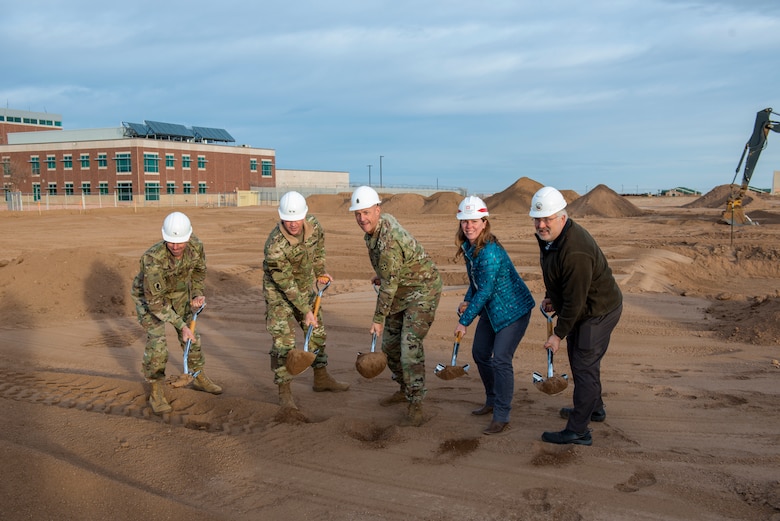 leaders shovel sand to mark the beginning of construction on a new fitness center