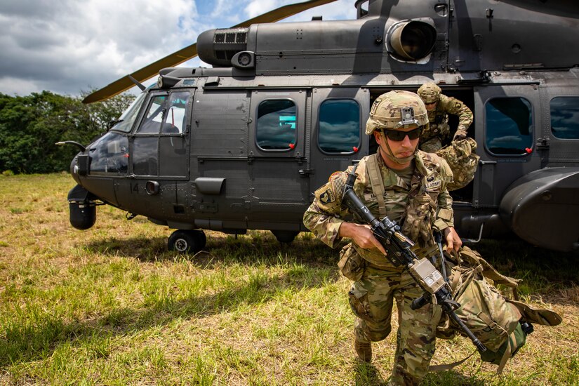 U.S. Army Soldier Shane Hayes, weapons squad leader with 1st Battalion, 187th Infantry Regiment, 3rd Brigade Combat Team, 101st Airborne Division (Air Assault) unload a Eurocopter AS532 Cougar during Exercise Southern Vanguard 22 in Lorena, Brazil, Dec. 3, 2021. U.S. and Brazilian army soldiers took part in the air assault exercise, which was the largest deployment of a U.S Army unit to train with the Brazilian army forces in Brazil. (U.S Army photo by Pfc. Joshua Taeckens)