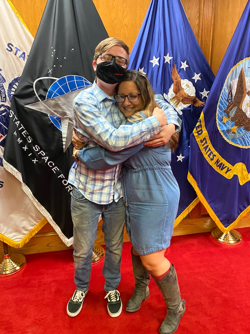 Dakota Veale hugs his stepmom, Air Force Liaison Erica Veale, after taking the Oath of Enlistment.