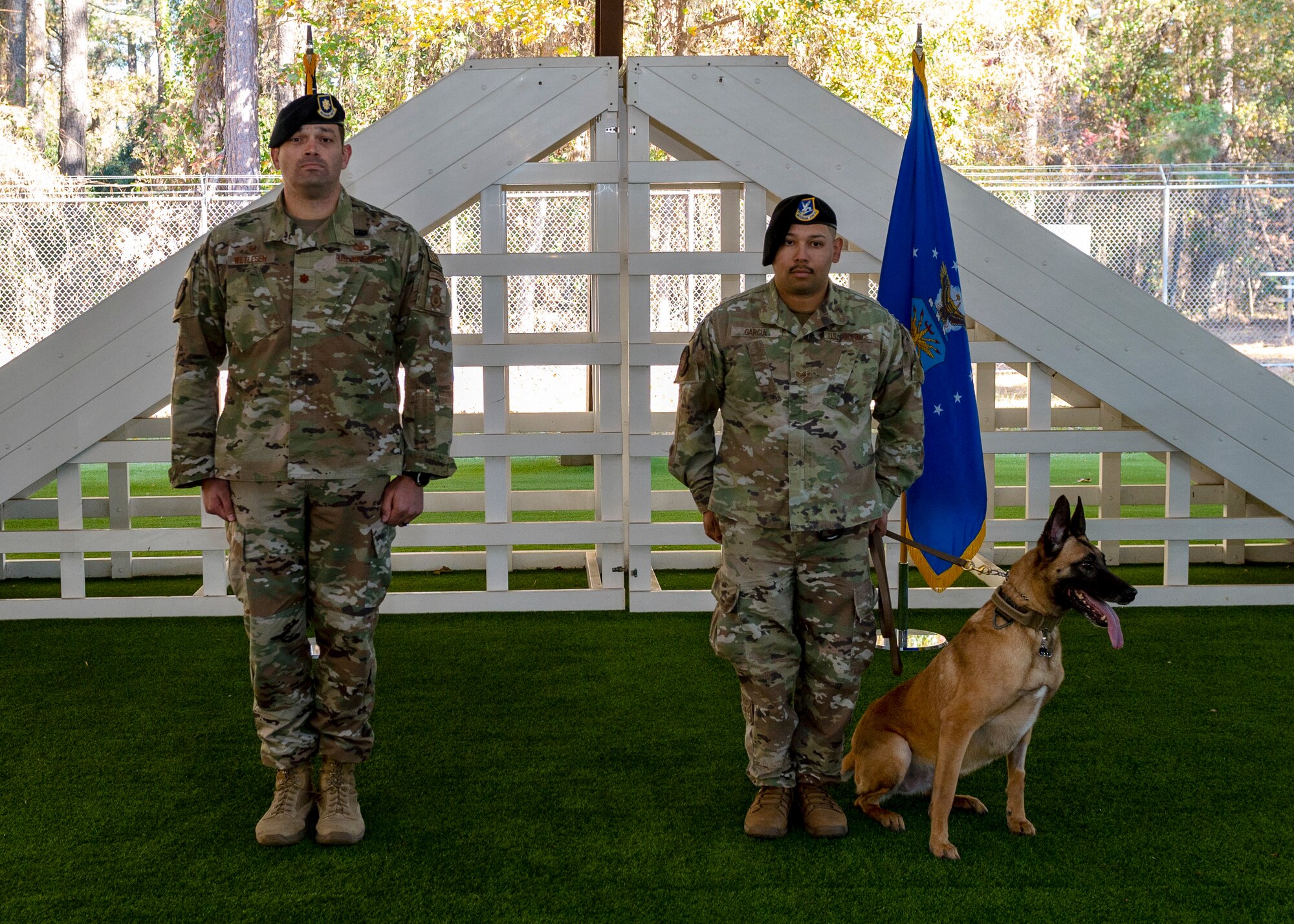 Maj. Michael Wetlesen, 4th Security Forces Squadron commander, and Staff Sgt. Joseph Garcia, 4th SFS military working dog handler stand at attention during MWD Tessa’s retirement ceremony at Seymour Johnson Air Force Base, North Carolina, Nov. 19, 2021