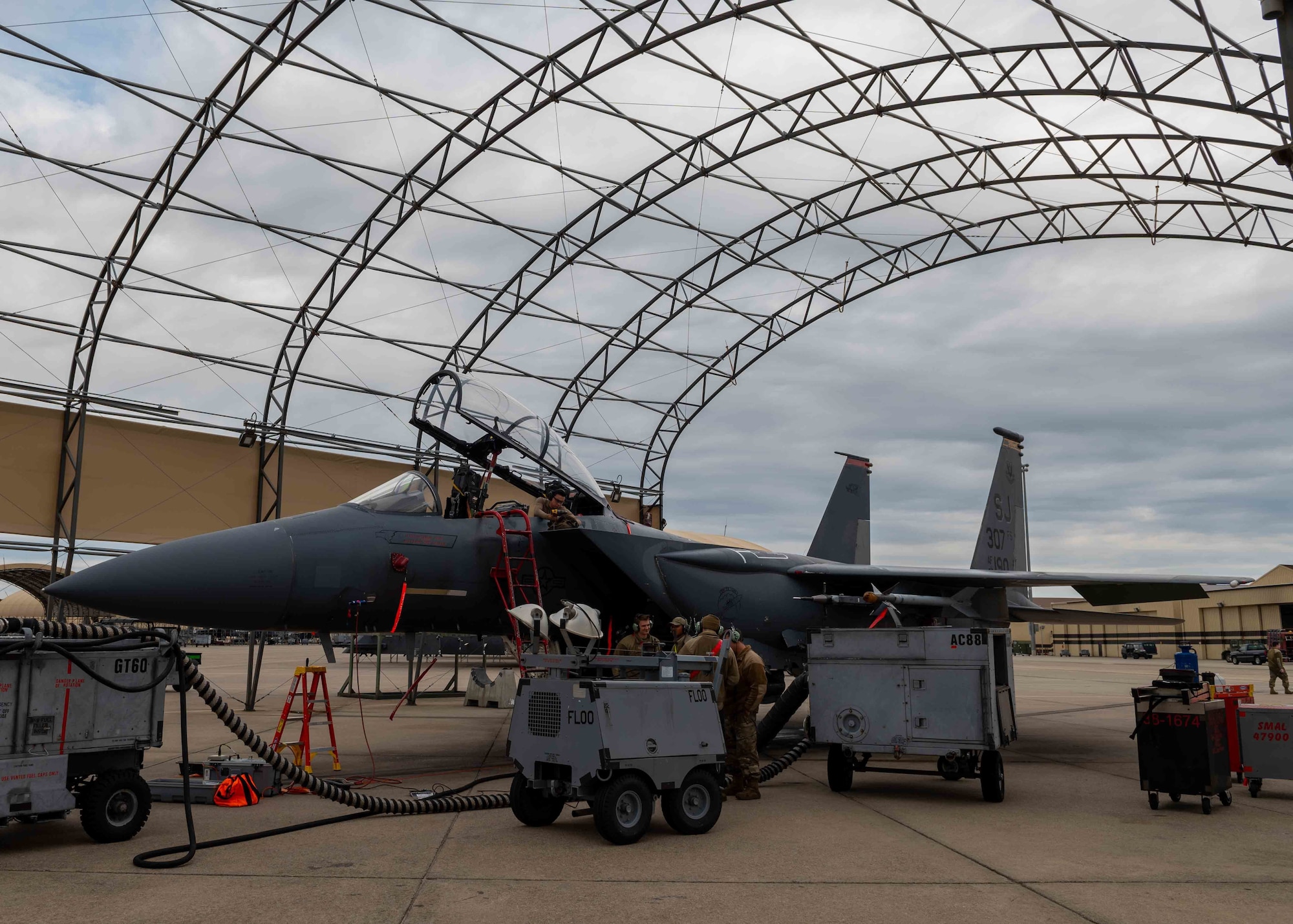 Airman 1st Class Kevin Esparza, top, 4th Equipment Maintenance Squadron aircraft structural maintenance technician, removes a stuck screw from inside the rear cockpit of an F-15E Strike Eagle at Seymour Johnson Air Force Base, North Carolina, Nov. 2, 2021.