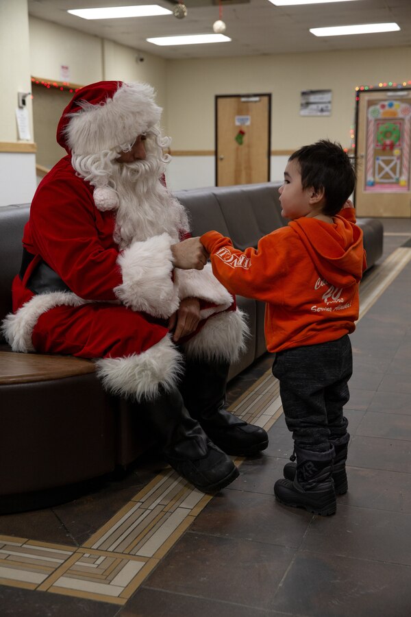 U.S. Marine Corps Gunnery Sgt. Jake Paolucci, Company Gunnery Sgt. of Delta Company, 4th Law Enforcement Battalion, Marine Forces Reserve, fist-bumps a child while dressed as Santa Claus in Kotzebue, Alaska, Dec. 11, 2021. The “Alaska Marines” of Delta Co., 4th LE Bn., are responsible for distributing toys with the Toys for Tots program across the state of Alaska. (U.S. Marine Corps photo by Cpl. Brendan Mullin)