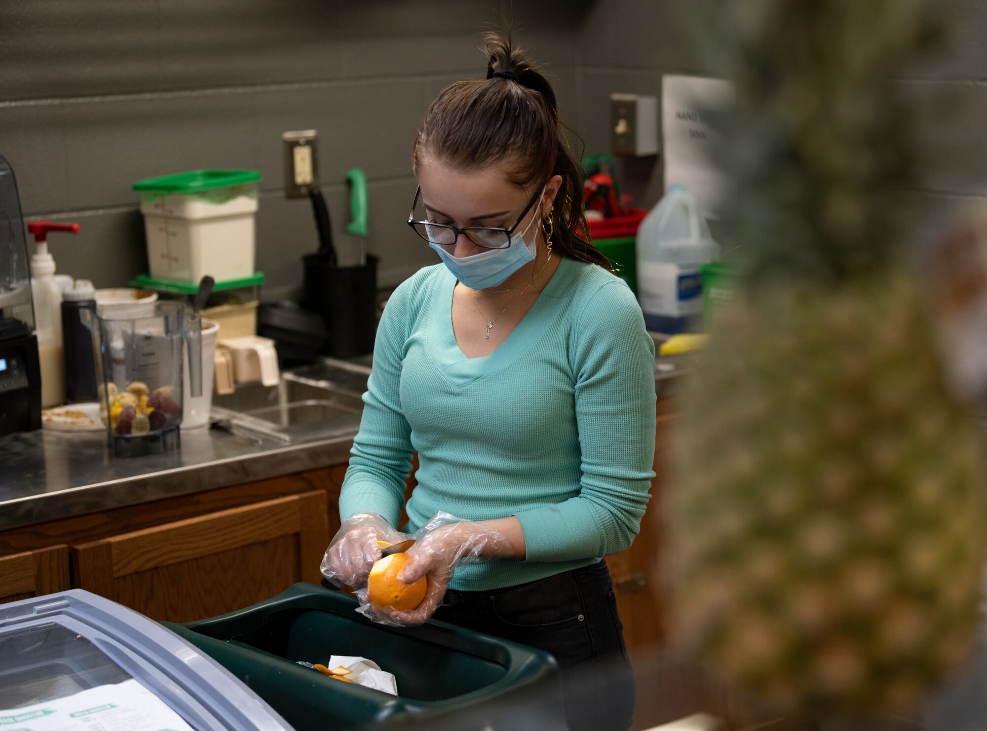Woman peels an orange.
