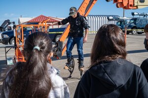 Gavin Stewart, 412th Civil Engineer Squadron, demonstrates an EskoVest exo-suit to students from Manzanita Elementary School in Palmdale during their visit to the 412th CES at Edwards Air Force Base, California, Dec. 8. (Air Force photo by Katherine Franco)