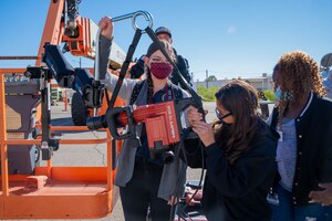 Madeline Greiner, STARBASE Edwards instructor, demonstrates an attachment to any scissor/boom/aerial bucket that increases productivity and reduce fatigue from operating heavy tools to students from Manzanita Elementary School in Palmdale during their visit to the 412th CES at Edwards Air Force Base, California, Dec. 8. (Air Force photo by Katherine Franco)