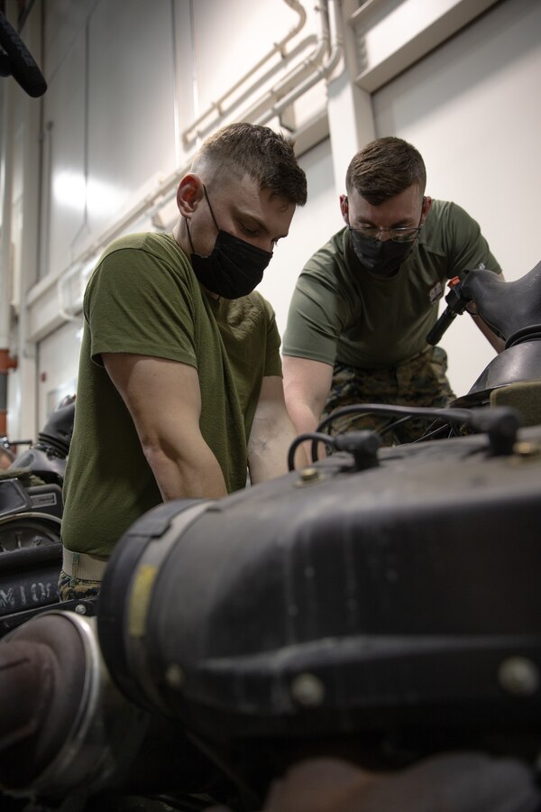 U.S. Marine Corps Lance Cpl. Devin Chissus, left, and Pfc. Micah Bedwell, both military police Marines with Delta Company, 4th Law Enforcement Battalion, Marine Forces Reserve, change the oil of a snowmobile at Joint Base Elmendorf-Richardson, Alaska, Dec. 3, 2021. The Marine Corps Reserve hosts the Toys for Tots program, collects donations of toys, and delivers them to school-aged children across the United States. (U.S. Marine Corps photo by Cpl. Brendan Mullin)