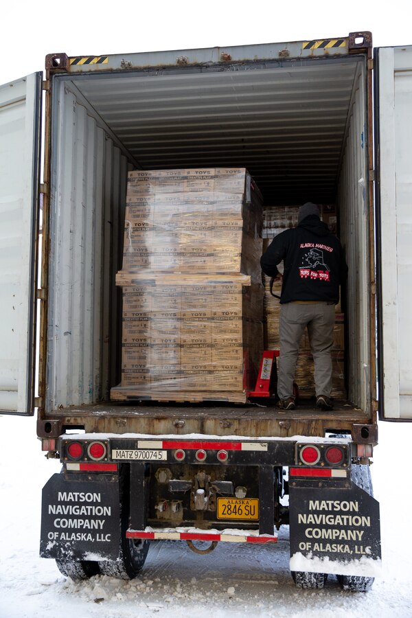 U.S. Marine Corps Gunnery Sgt. Jake Paolucci, Company Gunnery Sgt. with Delta Company, 4th Law Enforcement Battalion, Marine Forces Reserve, unloads pallets of toys from a tractor trailer at Joint Base Elmendorf-Richardson, Alaska, Dec. 6, 2021. The Marine Corps Reserves hosts the Toys for Tots program collects donations of toys and delivers them to school-aged children across the United States. (U.S. Marine Corps photo by Cpl. Brendan Mullin)