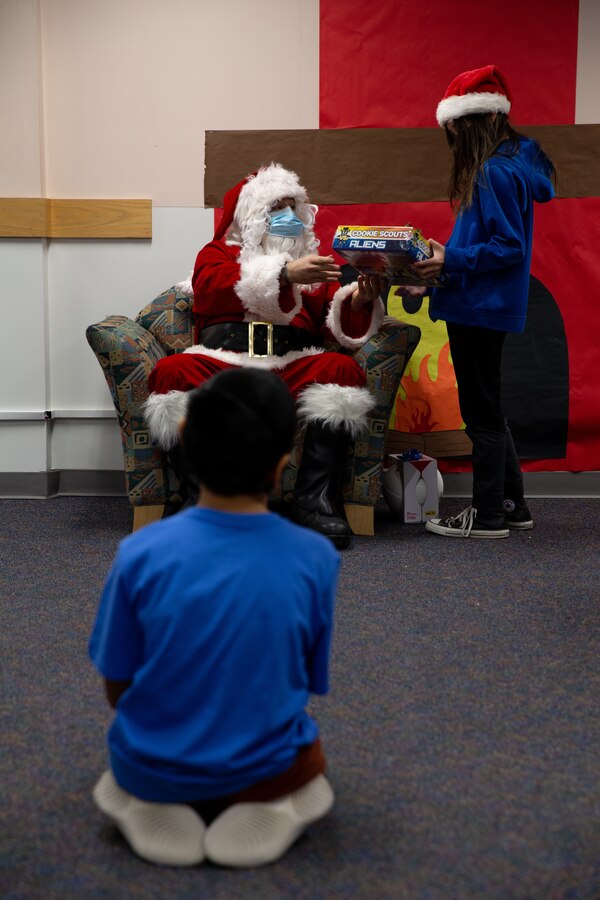 U.S. Marine Corps Gunnery Sgt. Jake Paolucci, Company Gunnery Sgt. of Delta Company, 4th Law Enforcement Battalion, Marine Forces Reserve, hands a gift to a student while dressed as Santa Claus in Kotzebue, Alaska, Dec. 10, 2021. The “Alaska Marines” of Delta Co., 4th LE Bn., are responsible for distributing toys with the Toys for Tots program across the state of Alaska. (U.S. Marine Corps photo by Cpl. Brendan Mullin)