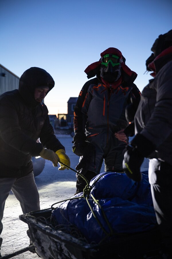 U.S. Marines with Delta Company, 4th Law Enforcement Battalion, Marine Forces Reserve, and local trail guides secure the contents of a sled before departing on snowmobiles in Kotzebue, Alaska, Dec. 12, 2021. The “Alaska Marines” of Delta Co., 4th LE Bn., are responsible for distributing toys with the Toys for Tots program across the state of Alaska. (U.S. Marine Corps photo by Cpl. Brendan Mullin)