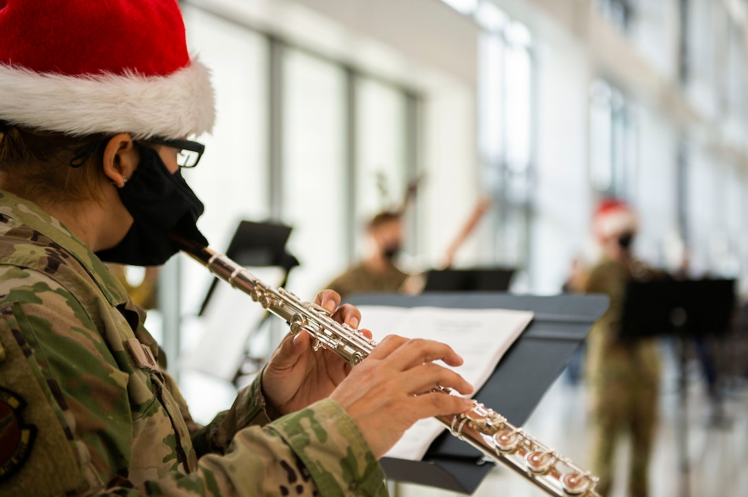 An airman plays the flute during a holiday performance.