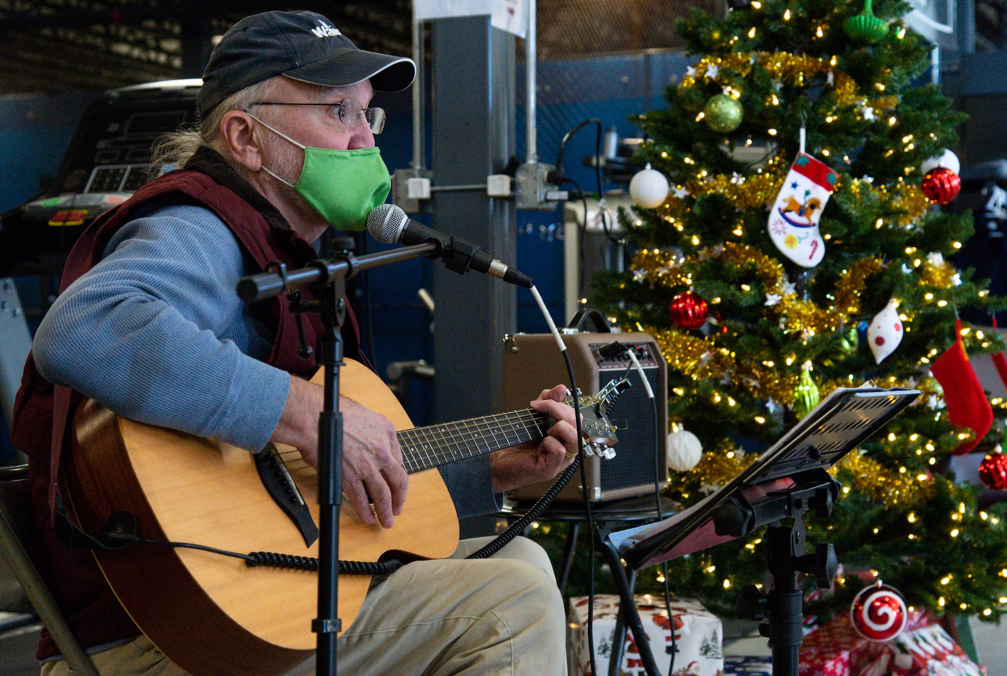Tom Hench, a local musician, plays his guitar during the Operation Feed the Troops on Dover Air Force Base, Delaware, Dec. 14, 2021. Hench played holiday songs as Team Dover members enjoyed a holiday meal at two different meal settings. (U.S. Air Force photo by Roland Balik)