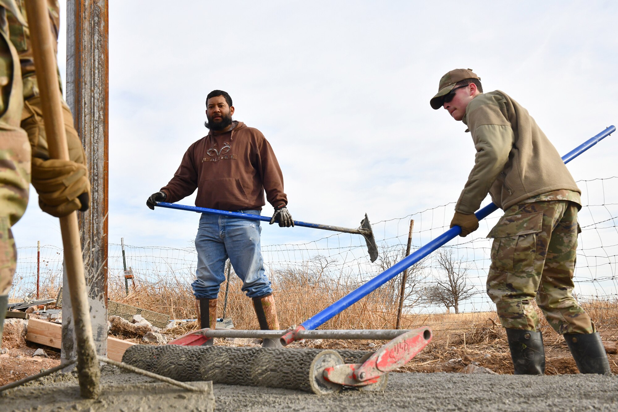 Members of the 97th Civil Engineer Squadron (CES) work on the concrete foundation of a new frangible flood gate at Altus Air Force Base, Oklahoma, Dec. 9, 2021. Each of these gates, designed and built by the 97 CES, saves an average of $90K per gate compared to similar work performed by contractors. (U.S. Air Force photo by Tech. Sgt. Robert Sizelove)