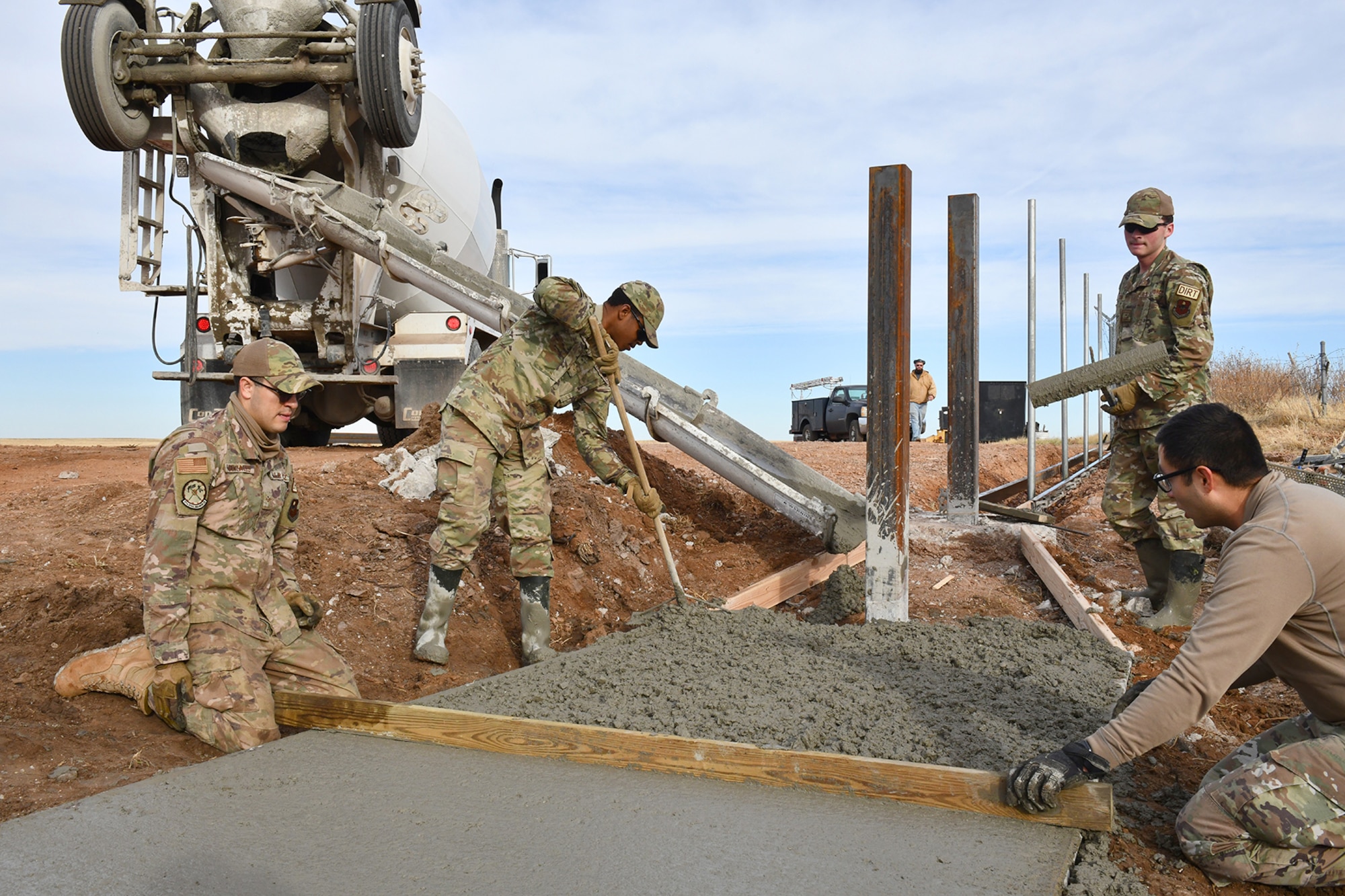 Members of the 97th Civil Engineer Squadron (CES) work on the concrete foundation of a new frangible flood gate at Altus Air Force Base, Oklahoma, Dec. 9, 2021. Each of these gates, designed and built by the 97 CES, saves an average of $90K per gate compared to similar work performed by contractors. (U.S. Air Force photo by Tech. Sgt. Robert Sizelove)