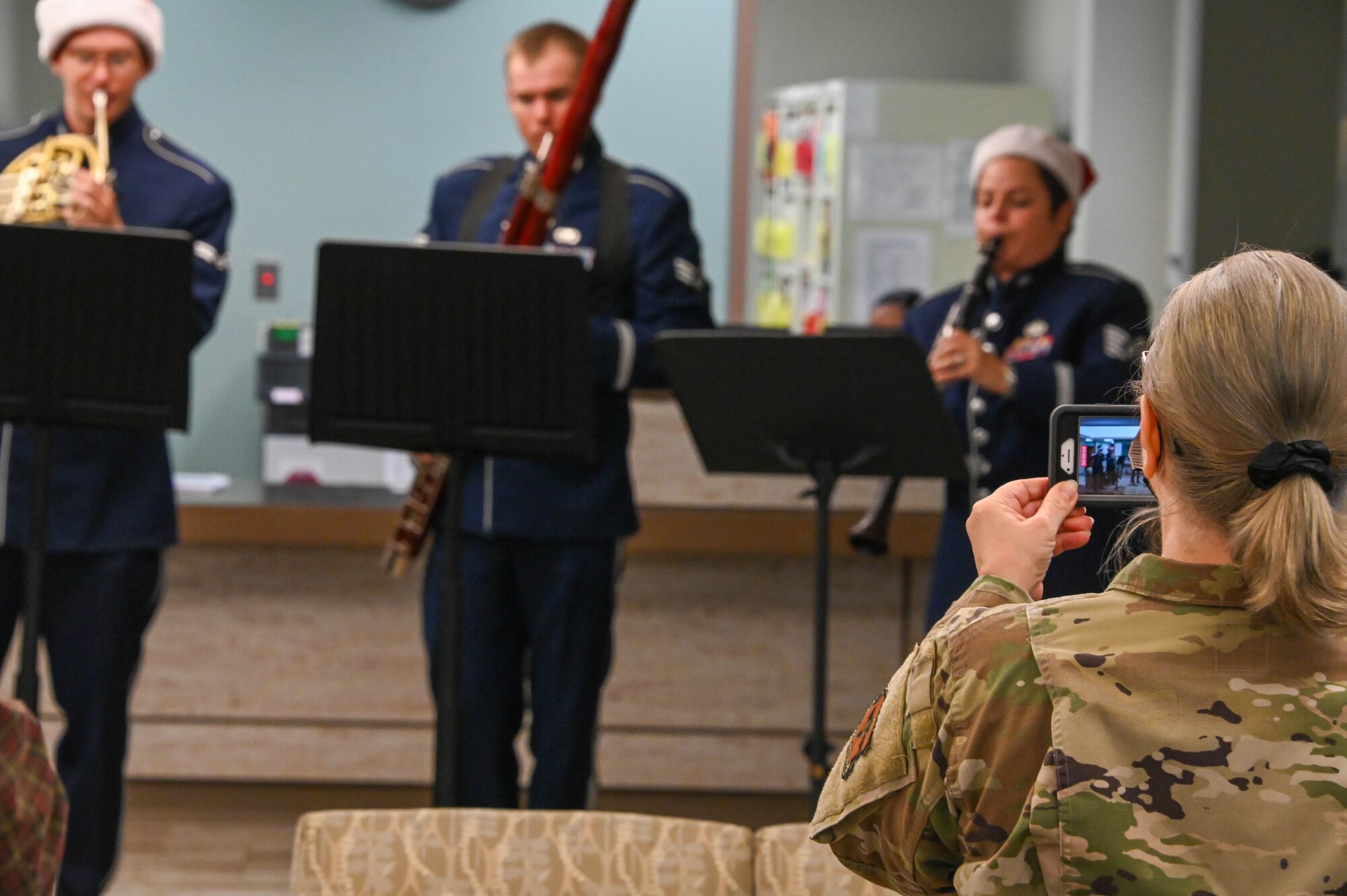 U.S. Air Force Col. Judy Rattan, 97th Medical Group (MDG) commander, records a video of the U.S. Air Force Band of the West performing at the 97th MDG at Altus Air Force Base, Oklahoma, Dec. 14, 2021. The USAF Band of the West has performed for presidents, heads of state, and dignitaries from around the world, earning an outstanding reputation among America's military bands. (U.S. Air Force photo by Airman 1st Class Kayla Christenson)