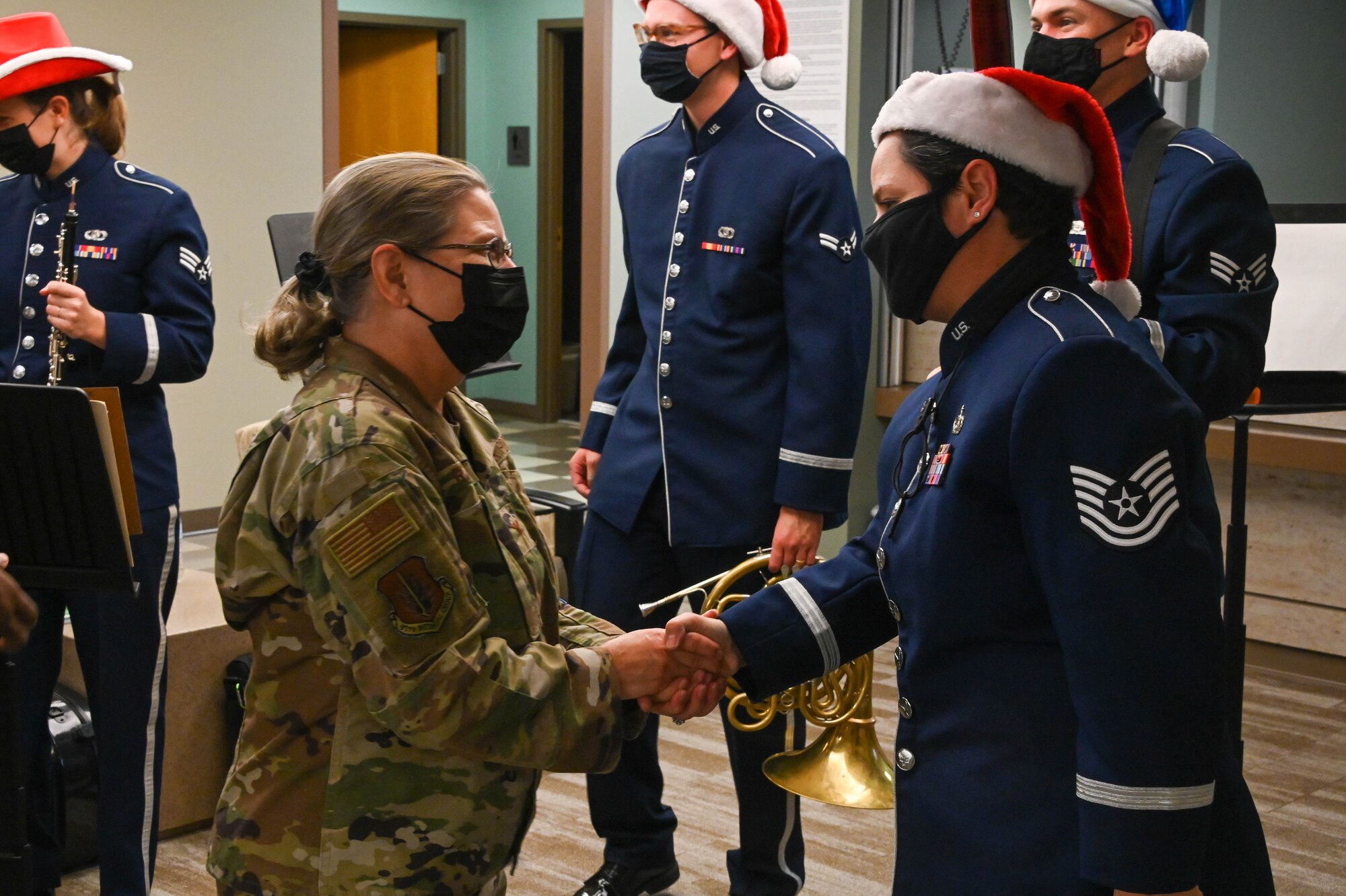 U.S. Air Force Tech. Sgt. Denise Cardona Santos, U.S. Air Force Band of the West clarinetist, is coined by Col. Judy Rattan, 97th Medical Group commander, at Altus Air Force Base, Oklahoma, Dec. 14, 2021. The USAF Band of the West performed at numerous locations on base, including the Base Exchange, Child Development Center, Club Altus, the 97th Mission Support Group. (U.S. Air Force photo by Airman 1st Class Kayla Christenson)