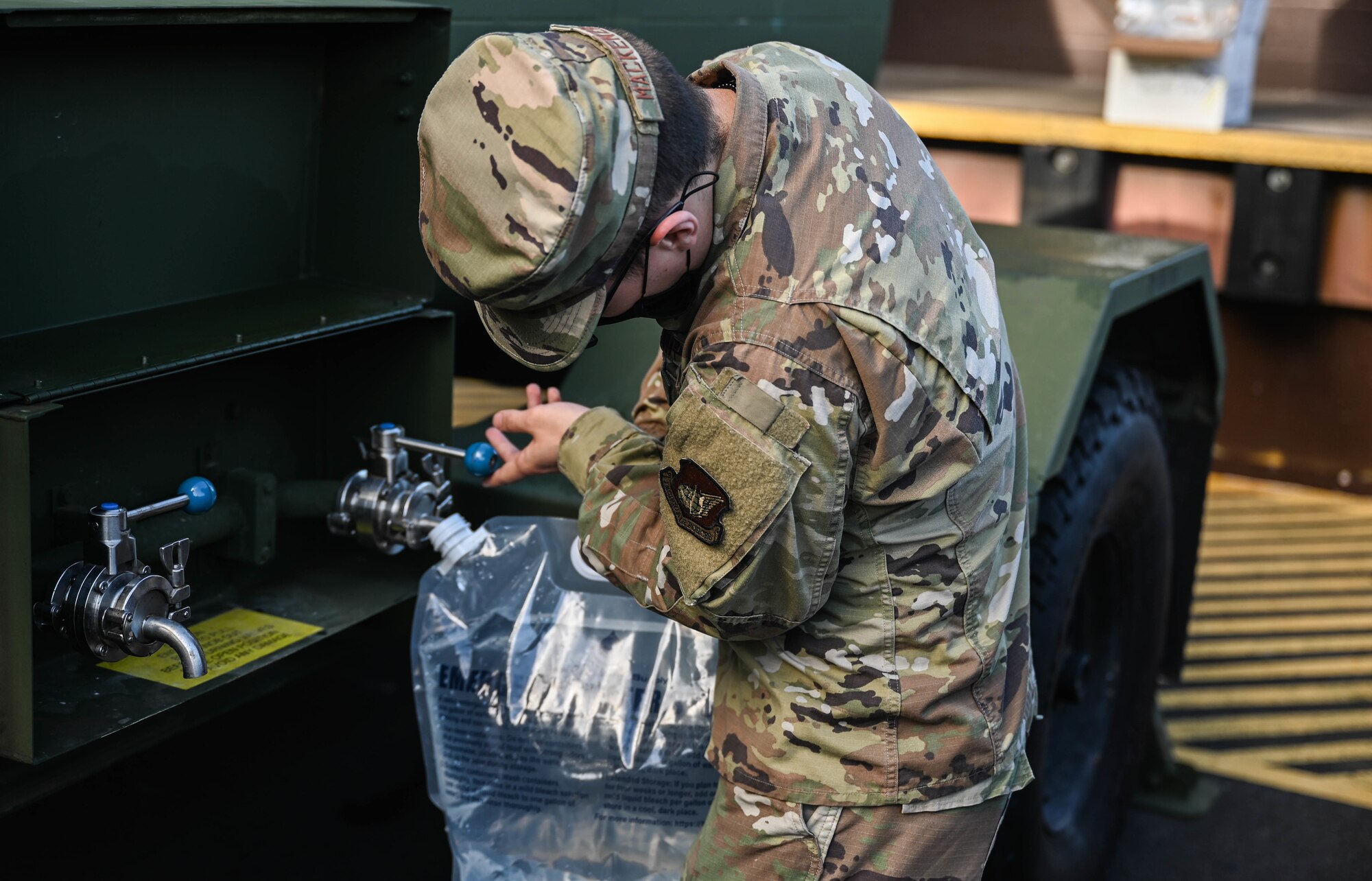 Airman 1st Class Jacob MacKenzie, 647th Force Support Squadron food service journeyman, fills a storage container with water from a potable water source at the Hale Aina Dining Facility at Joint Base Pearl Harbor-Hickam, Hawaii, Dec. 16, 2021. As a precautionary measure, the dining facility utilizes up to 80 gallons of potable water per day to provide customers with food. The water source at the facility is one of 17 locations on the Hickam side of JBPHH that is tested for contaminants. (U.S. Air Force photo by Staff Sgt. Alan Ricker)