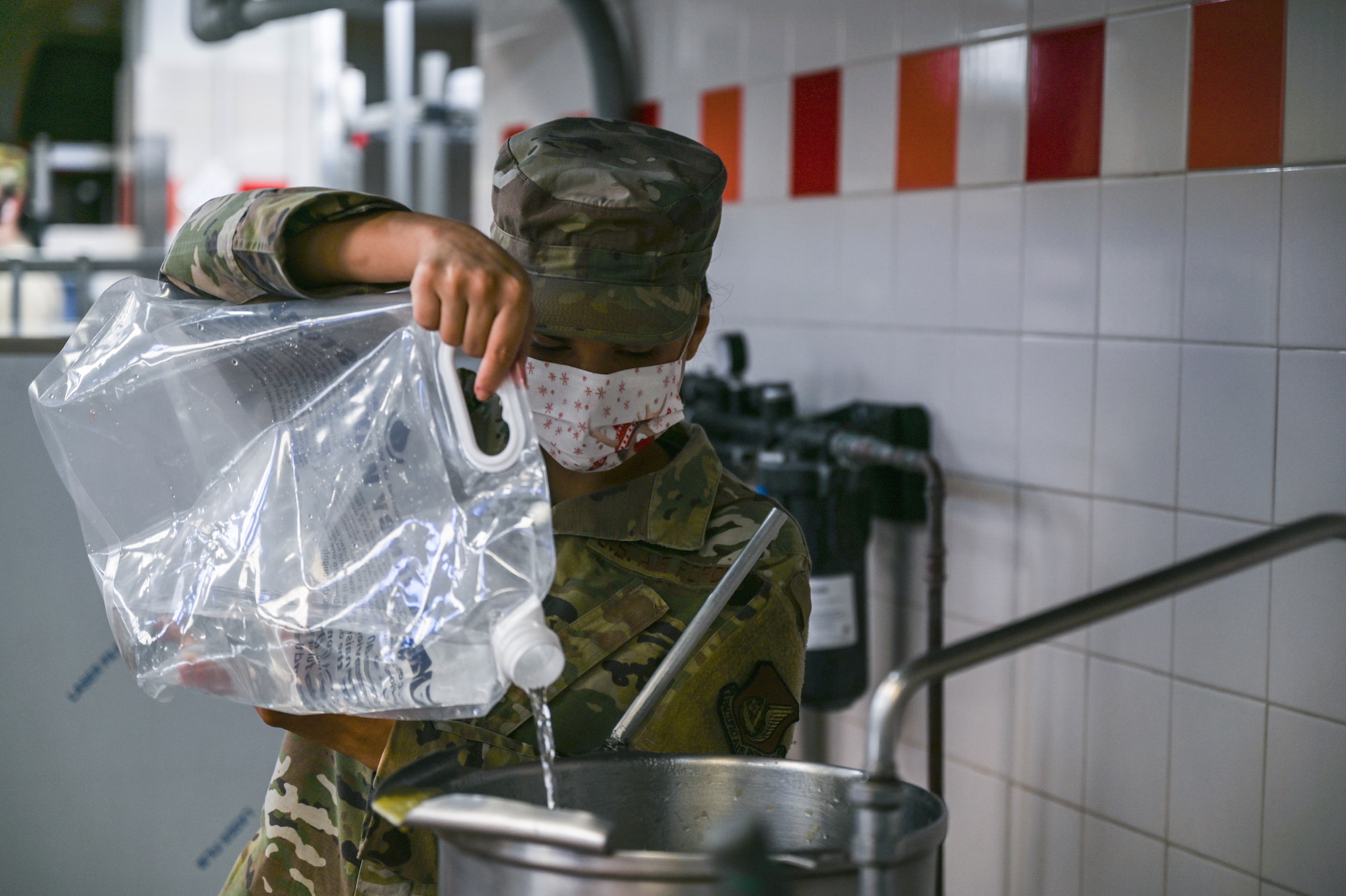 Staff Sgt. Sarah Sanez, 647th Force Support Squadron food service supervisor, utilizes water from a potable source to clean cooking equipment in the Hale Aina Dining Facility at Joint Base Pearl Harbor-Hickam, Hawaii, Dec. 16, 2021. The Hale Aina staff are providing food made with potable water as a precautionary measure. The facility uses up to 80 gallons of potable water per day and is one of 17 locations regularly screened for contaminants on the Hickam side of JBPHH. (U.S. Air Force photo by Staff Sgt. Alan Ricker)