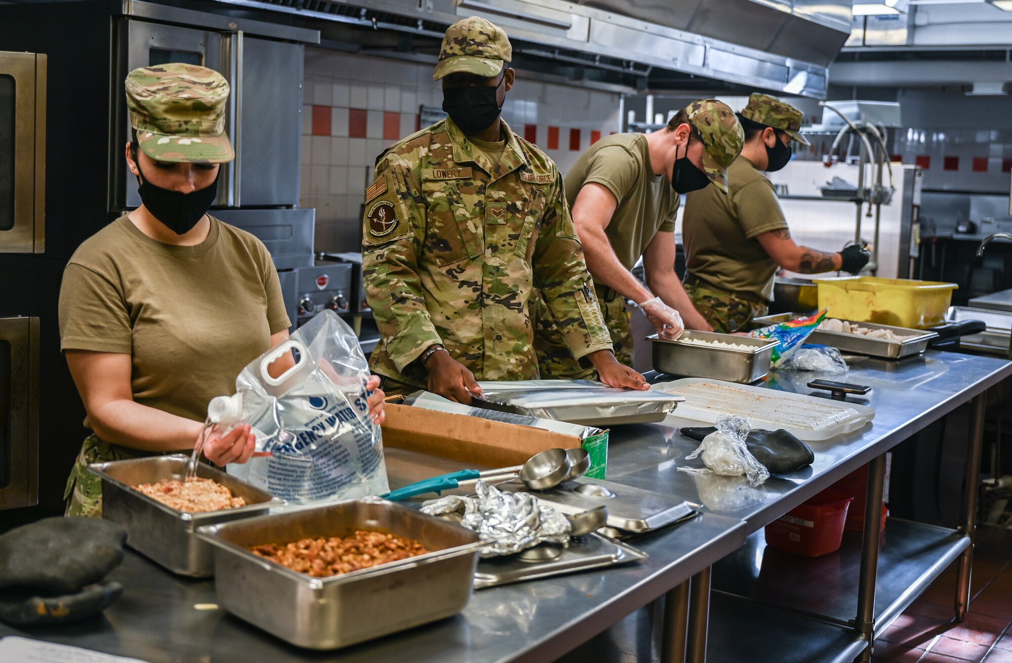 Food service Airmen assigned to the 647th Force Support Squadron, prepare lunch in the Hale Aina Dining Facility at Joint Base Pearl Harbor-Hickam, Hawaii, Dec. 16, 2021. The facility’s potable water source, which is used to provide 80 gallons of water a day, is screened by the 15th Operational Medical Readiness Squadron bioenvironmental engineering flight for any contaminants as a precaution. (U.S. Air Force photo by Staff Sgt. Alan Ricker)
