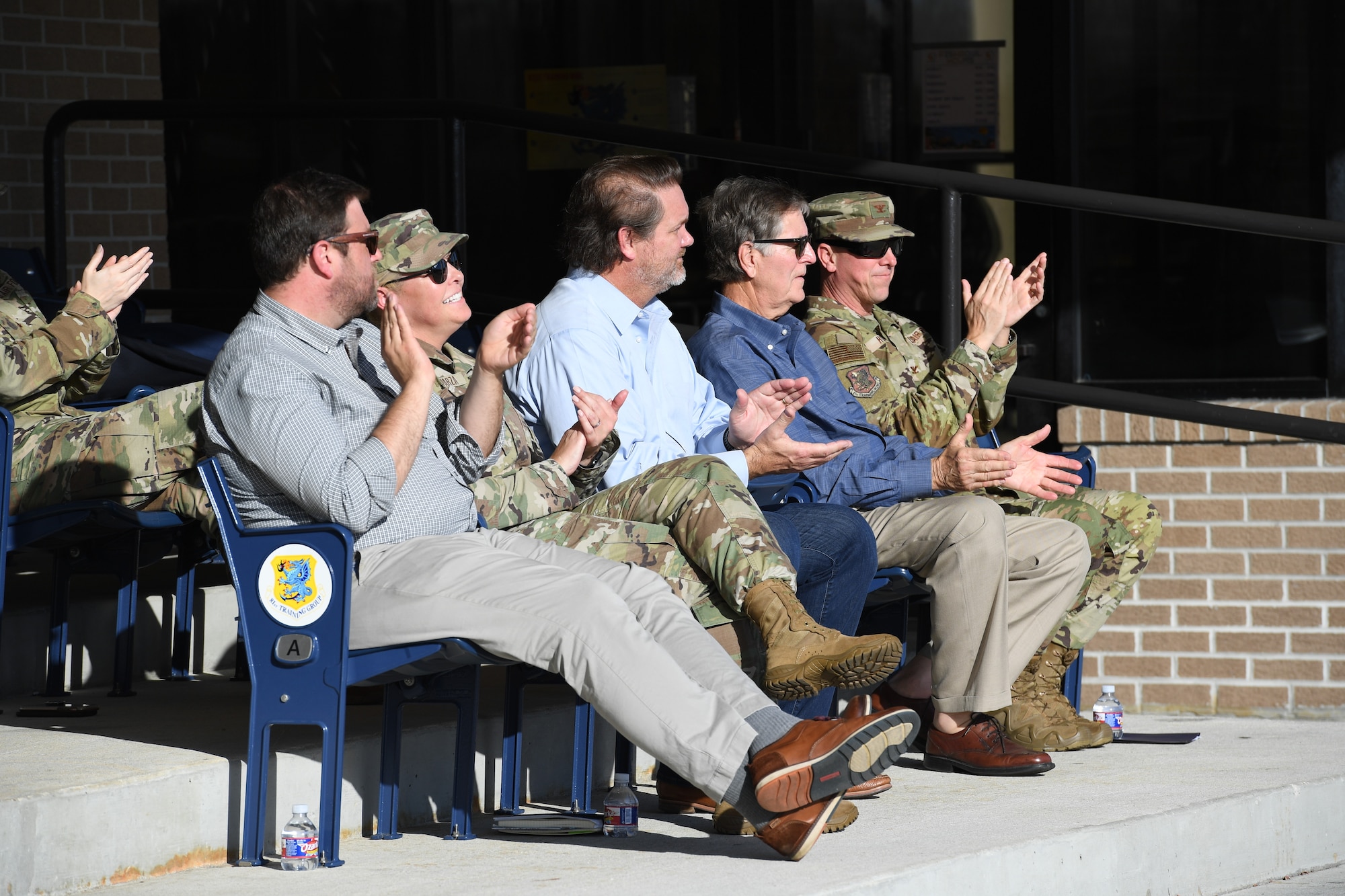 Keesler Civic Leaders and Keesler leadership applaud during an 81st Training Group drill team demonstration behind the Levitow Training Support Facility at Keesler Air Force Base, Mississippi, Dec. 16, 2021. The drill down demonstration showcased the camaraderie of the 81st TRG and the importance of partnerships. (U.S. Air Force photo by Kemberly Groue)
