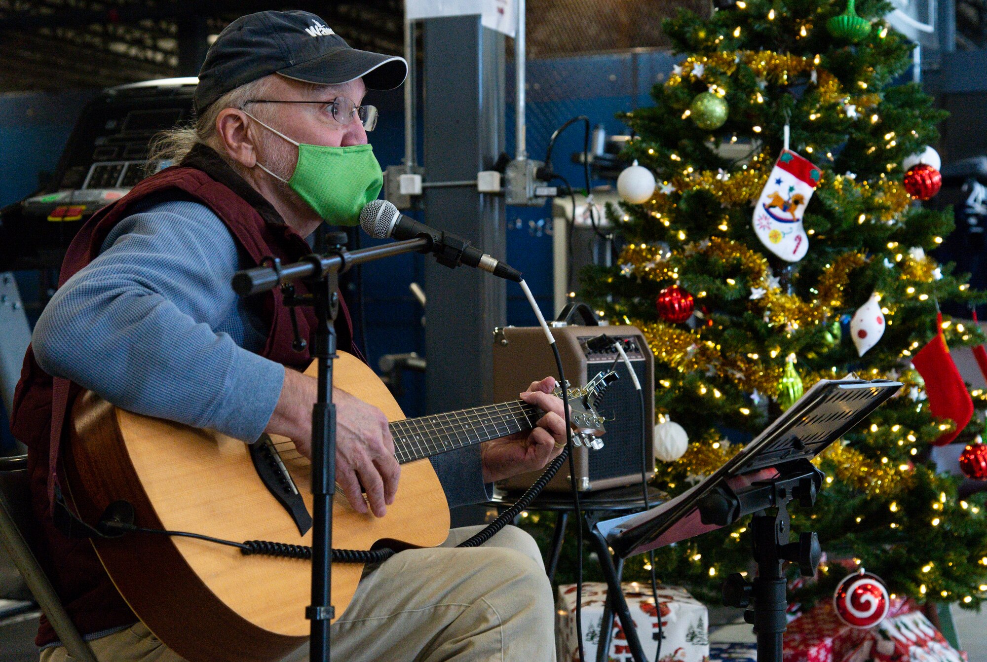 Tom Hench, a local musician, plays his guitar during the Operation Feed the Troops on Dover Air Force Base, Delaware, Dec. 14, 2021. Hench played holiday songs as Team Dover members enjoyed a holiday meal at two different meal settings. (U.S. Air Force photo by Roland Balik)