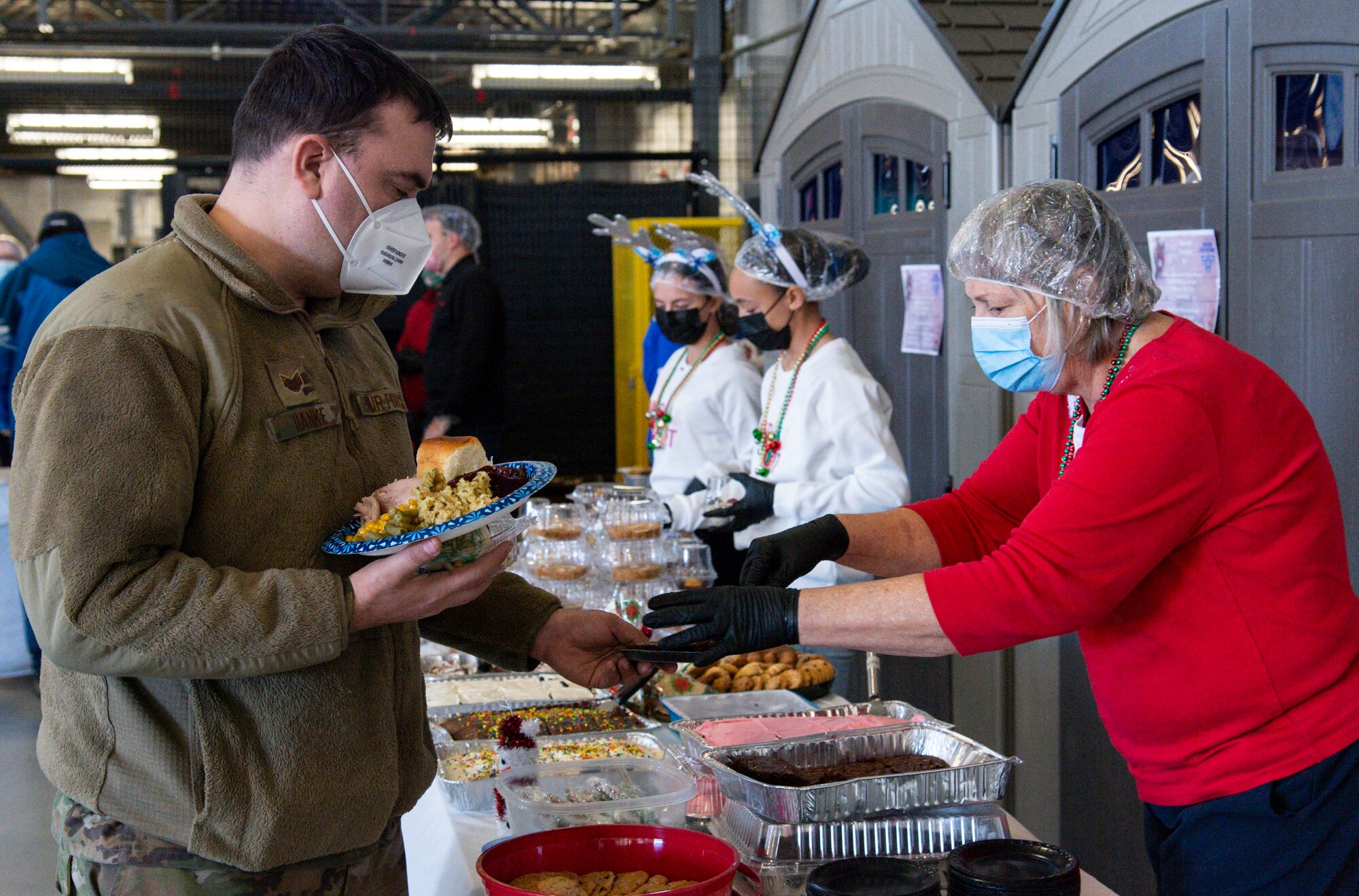 Staff Sgt. Robert Hanke, 736th Aircraft Maintenance Squadron aircraft support craftsman, gets dessert during Operation Feed the Troops on Dover Air Force Base, Delaware, Dec. 14, 2021. More than 30 volunteers served a traditional holiday meal to more than 900 Team Dover members. (U.S. Air Force photo by Roland Balik)