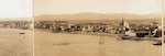 Part of a panoramic photograph of Nome, with the small white Nome Boat Station located in the center. Note the proximity of the boathouse to the open beach and the degree of exposure to high seas. (Library of Congress)