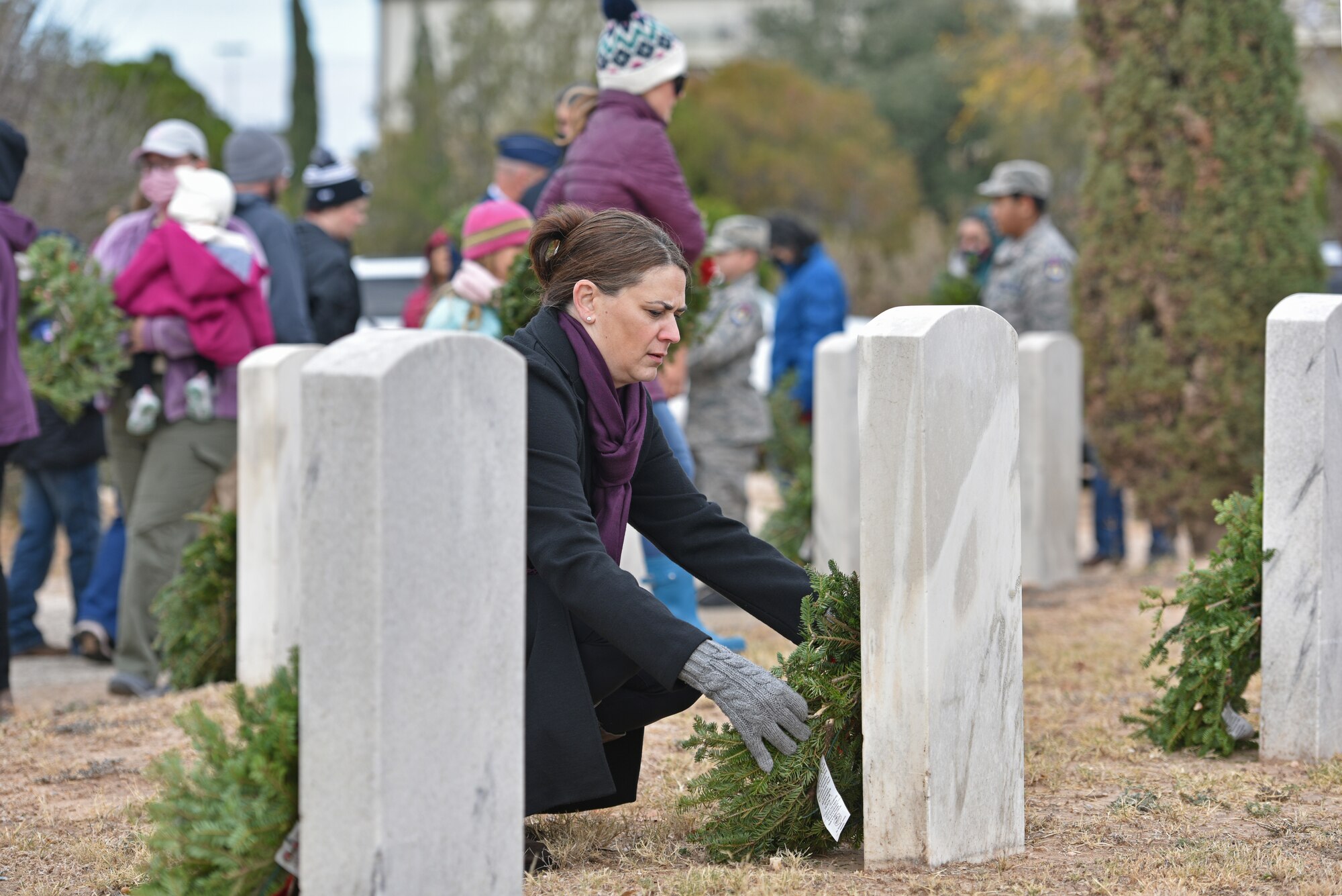 Katie Reilman, 17th Training Wing command team spouse, places a wreath during the Wreaths Across America ceremony at Belvedere Memorial Park Cemetery in San Angelo, Texas, Dec. 18, 2021. Following the ceremony, over 300 wreaths were placed across Belvedere Memorial Park Cemetery. (U.S. Air Force photo by Senior Airman Ashley Thrash)