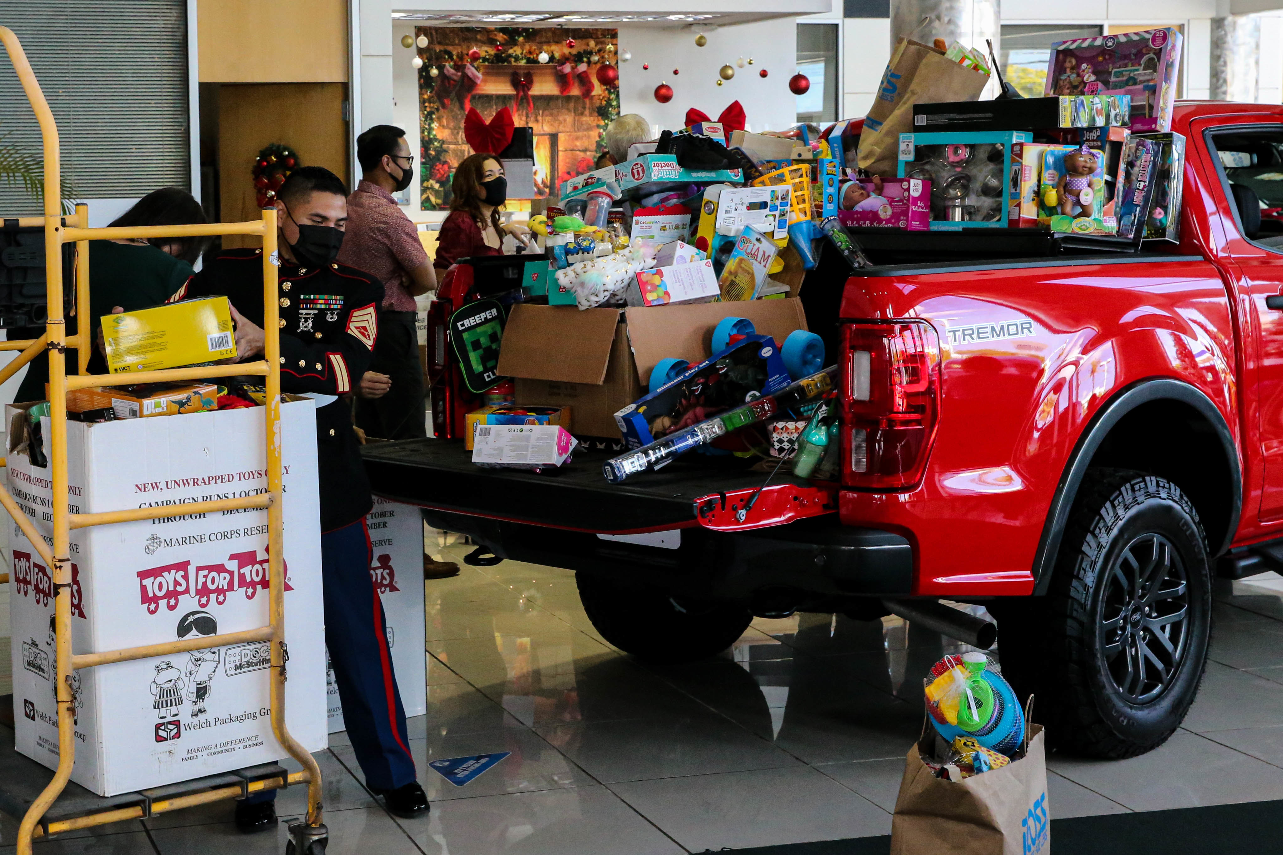 U.S. Marine Corps Gunnery Sgt. Rubin Tan, the assistant coordinator for Toys for Tots on Guam and the Commonwealth of the Northern Mariana Islands, collects toys from a local car dealership during a toy collection in Tamuning, Guam, Dec. 10, 2021.