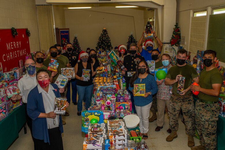 U.S. Marines assigned to Marine Corps Base (MCB) Camp Blaz and local community members pose for a group photo during a Toys for Tots toy transfer event to local charities on Guam, Dec. 17, 2021.