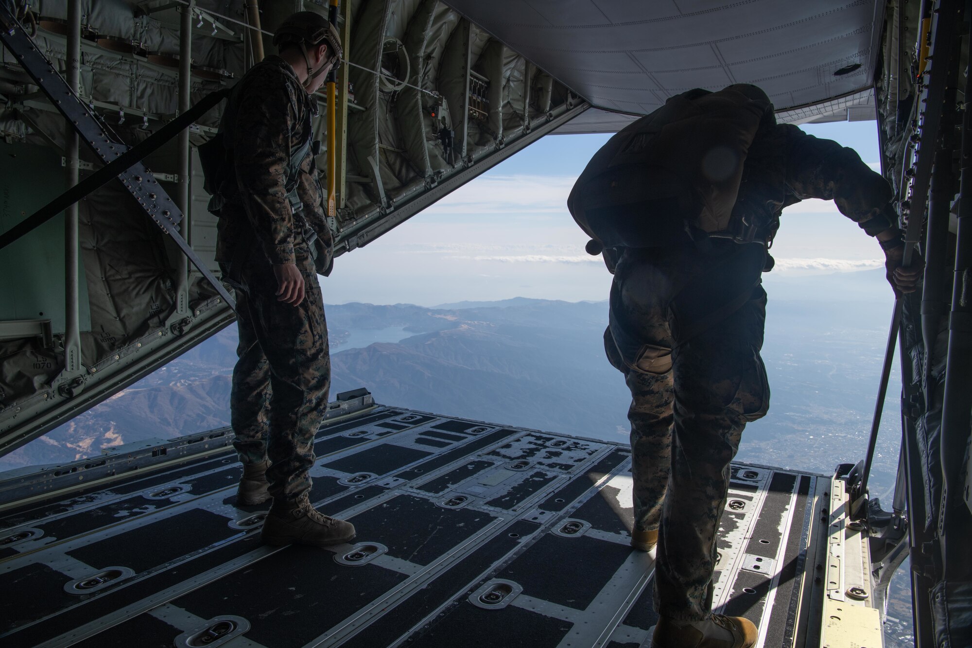 Marines assigned to the 3rd Reconnaissance Battalion, 3rd Marine Division, monitor jump progress during a high altitude, low opening (HALO) parachute jumps at Yokota Air Base, Japan, Dec. 17, 2021