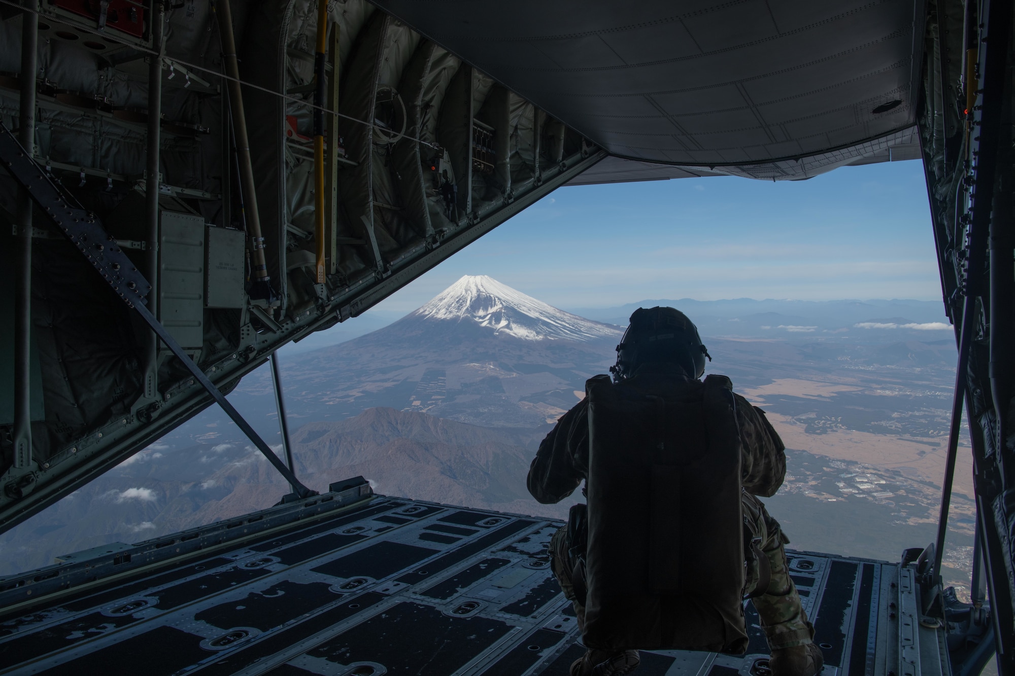 U.S. Air Force Staff. Sgt. Jordan Silversmith, 36th Airlift Squadron instructor loadmaster, surveys the land in support of a high altitude, low opening (HALO) parachute jumps at Yokota Air Base, Japan, Dec. 17, 2021