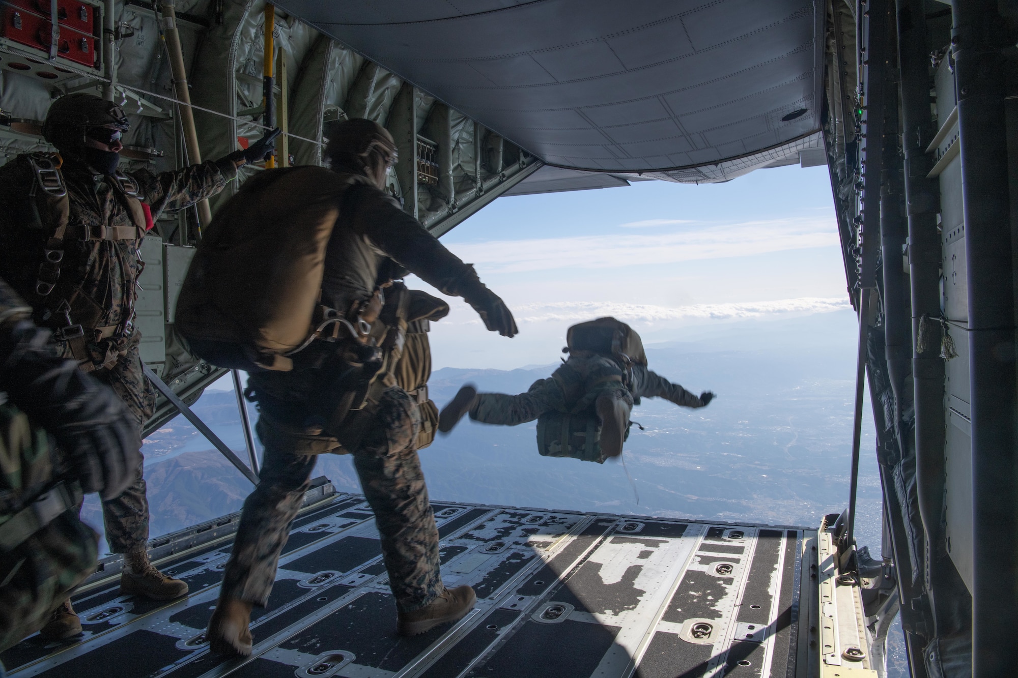 Marines assigned to the 3rd Reconnaissance Battalion, 3rd Marine Division, jump from the loading dock of a 36th Airlift Squadron C-130J Super Hercules during high altitude, low opening (HALO) parachute jumps at Yokota Air Base, Japan, Dec. 17, 2021