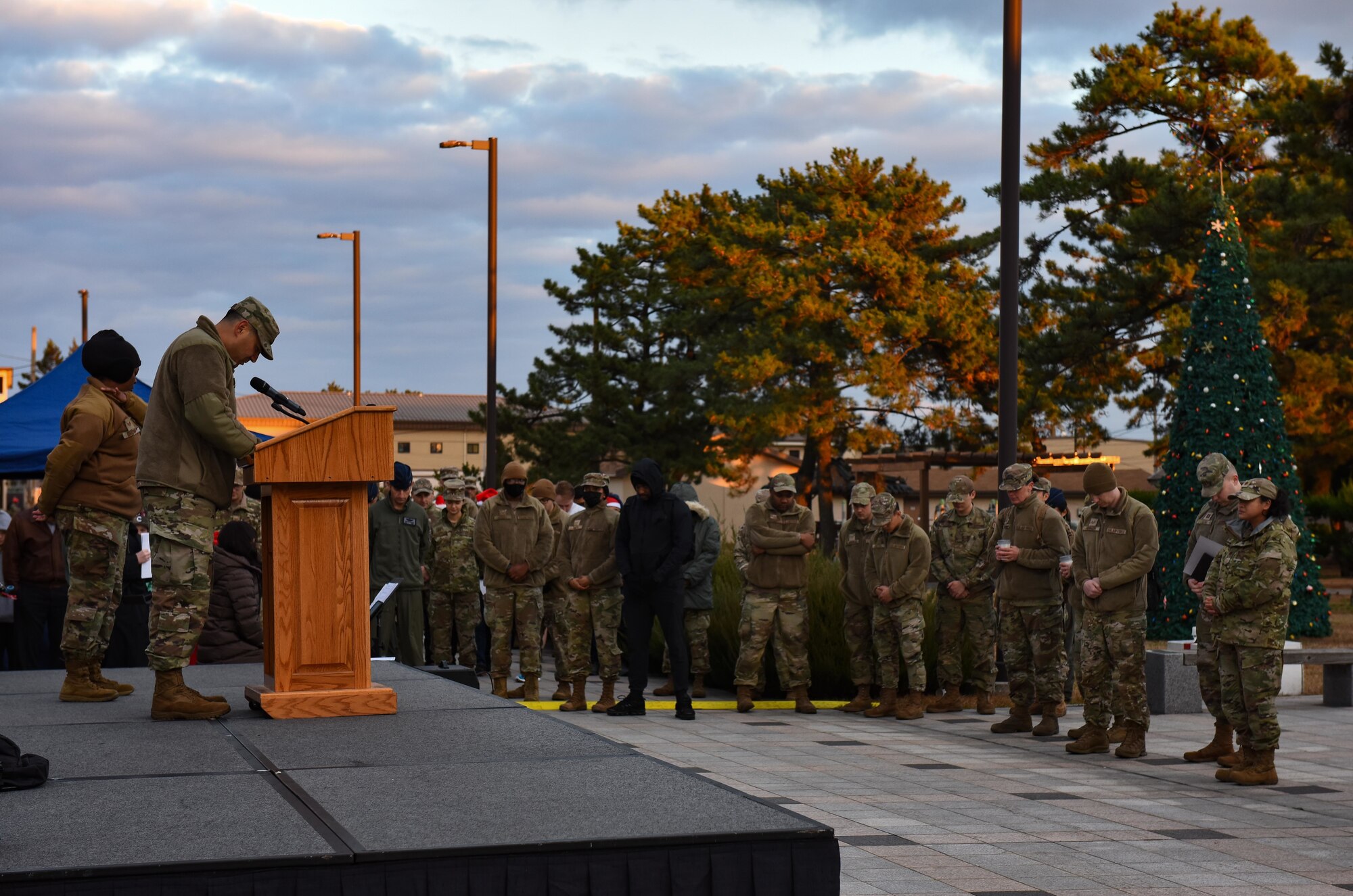 Service members bow their heads.